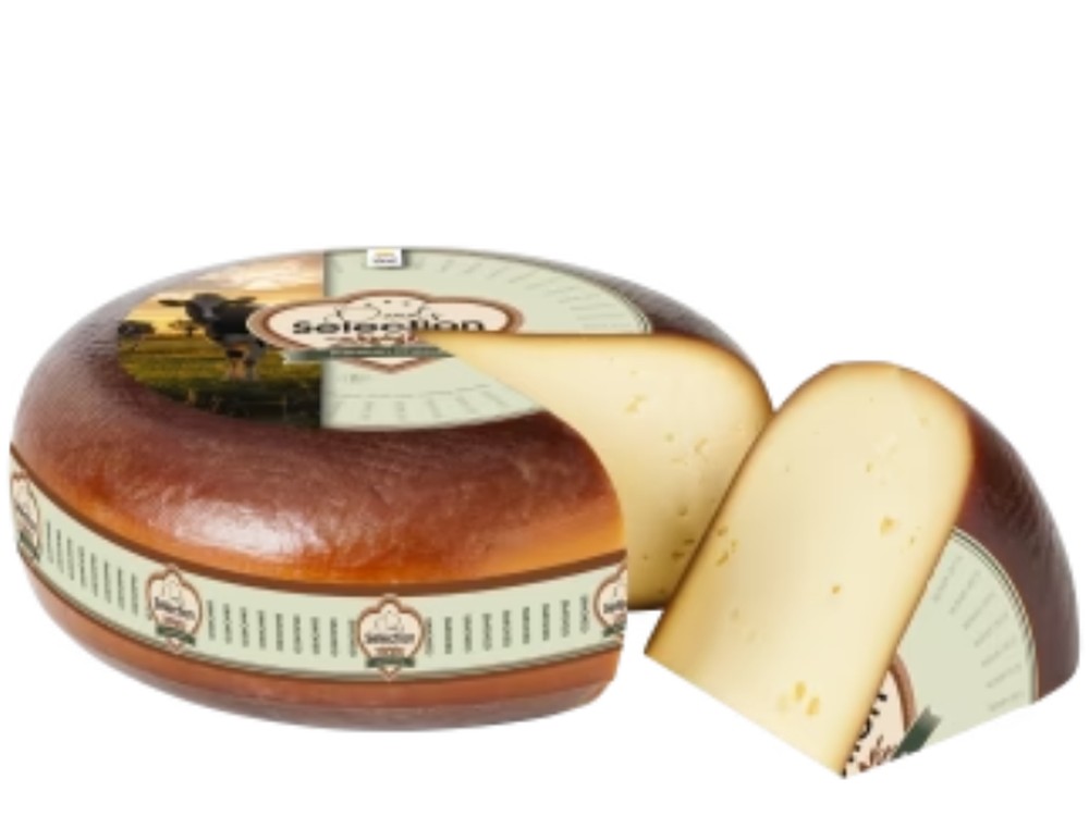 A partially cut wheel of Smoked Gouda cheese, along with a slice, placed against a white background