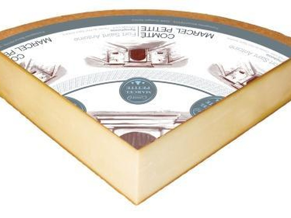 A triangular slice of Comté Symphonie, aged 16-24 months, with a label on top, is set against a white background