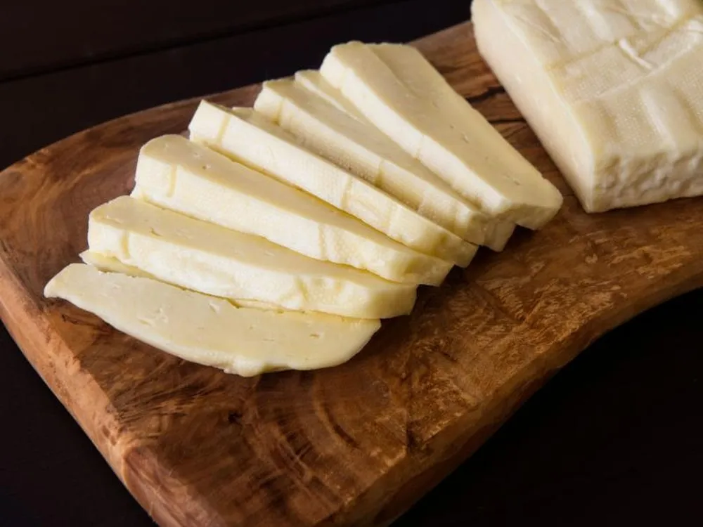 Slices of Garnie cheese neatly arranged on a wooden surface