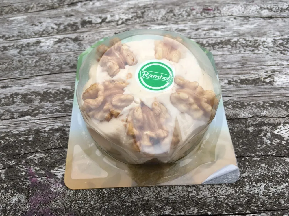 Rambol cheese packet showing crunchy walnuts sits on a wooden surface