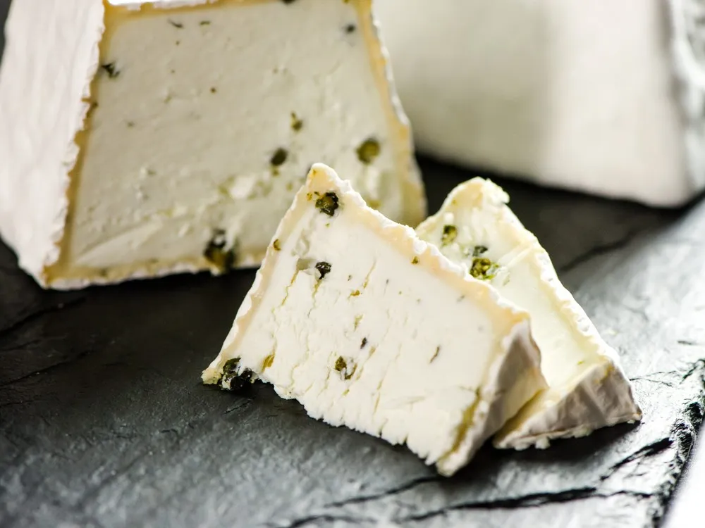 The brick-shaped Detroit Street Brick, with slices showing a velvety mold coating and an interior studded with freshly cracked green peppercorns