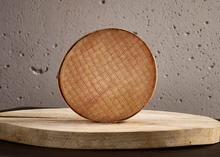 A round-shaped Stinking Bishop cheese with a brownish rind placed on a wooden surface