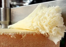 A wheel of Tête de Moine cheese with rosettes (cheese curls) alongside a Cheese Curler