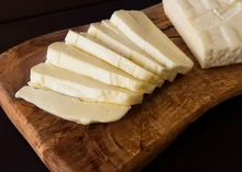 Slices of Garnie cheese neatly arranged on a wooden surface