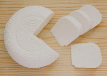 Slices of Queso panela, a Mexican cheese arranged on a wooden surface