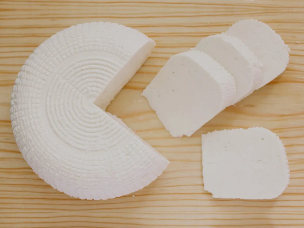 Slices of Queso panela, a Mexican cheese arranged on a wooden surface