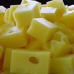 Blocks of Swiss cheese displaying a pale yellow color and distinctive holes ('eyes')